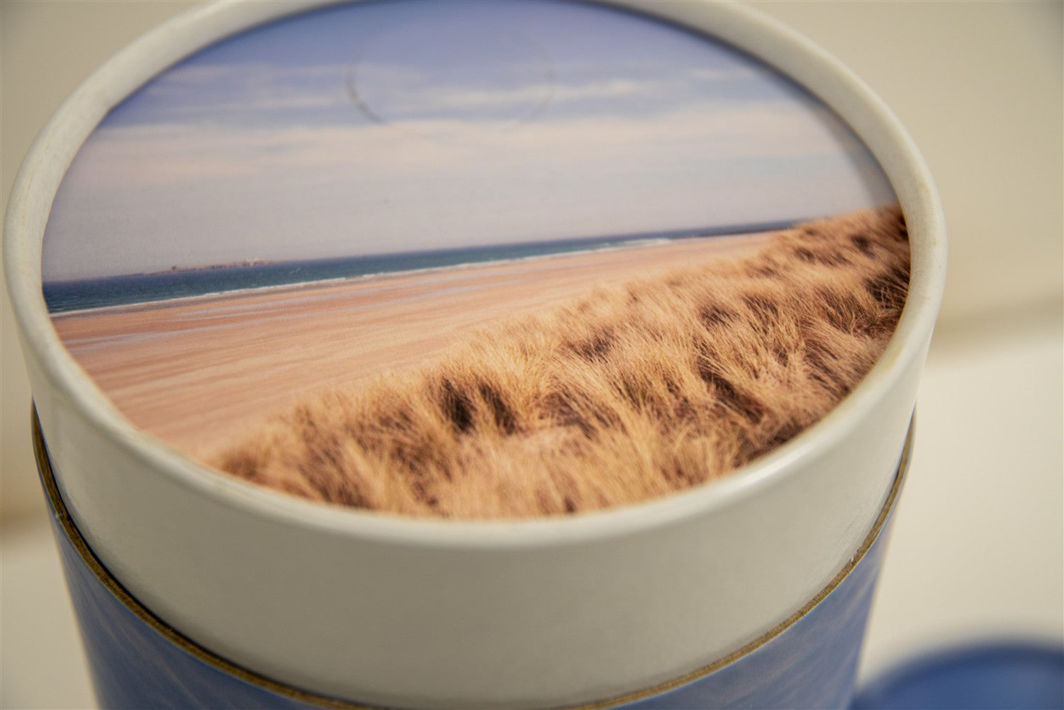 A closeup of a scatter tube with a beach design