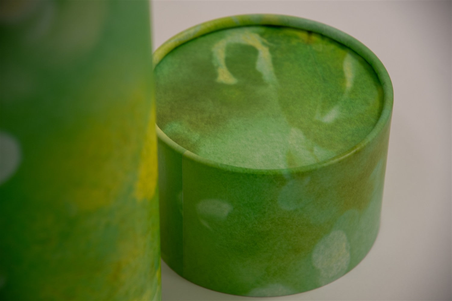 A closeup of scatter tube with a green verdant design