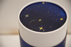 A closeup of a scatter tube with a starry night painting design