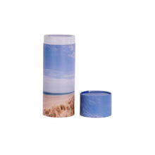 A scatter tube with a beach design showing the lid removed